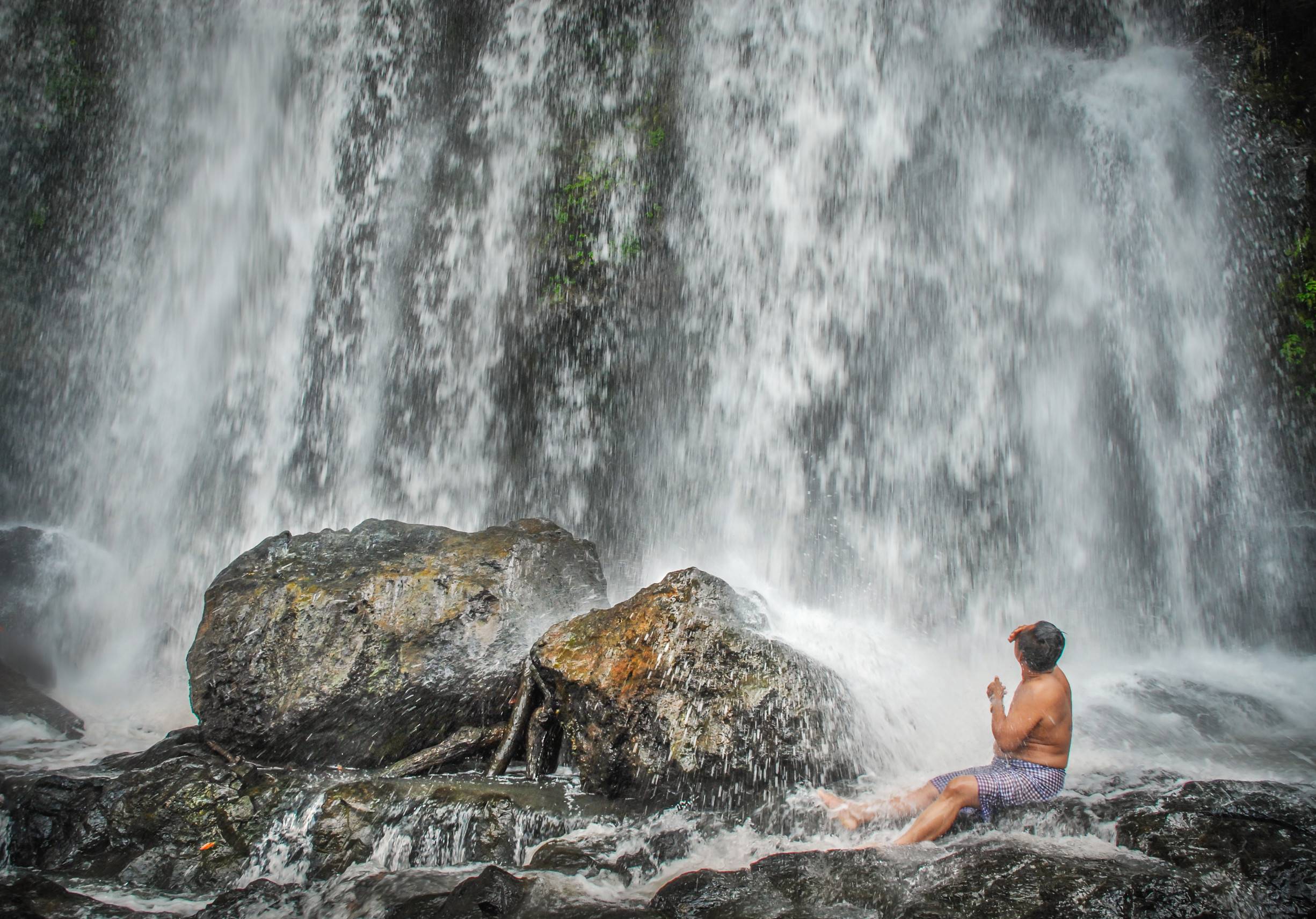 Man bathing under Bou Sra waterfall, Cambodia