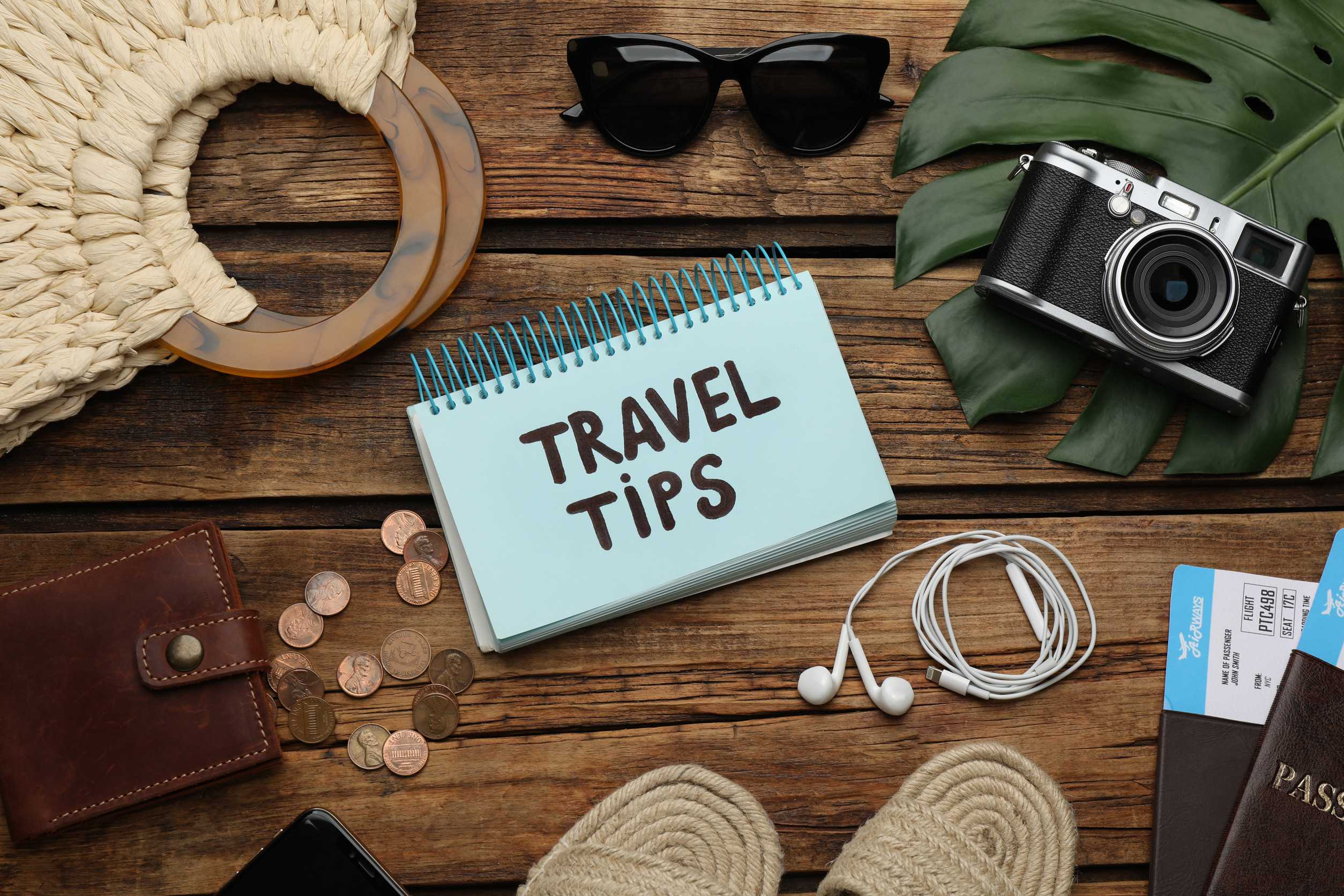 Travel Tips And Tourist Items On Wooden Table Flat Lay
